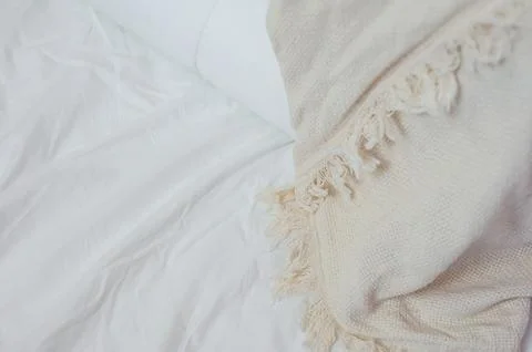 Stack of white pillows and blankets lies on the bed on a white sheet on top Stock Photos