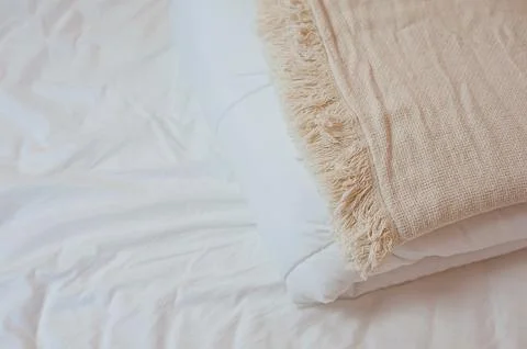Stack of white pillows and blankets lies on the bed on a white sheet on top Foto stock