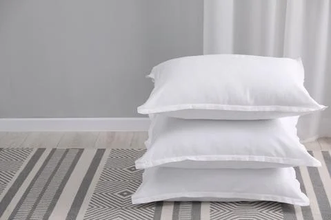Stack of white pillows on floor indoors. Space for text 스톡 사진