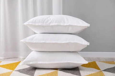 Stack of white pillows on floor indoors Stock Photos