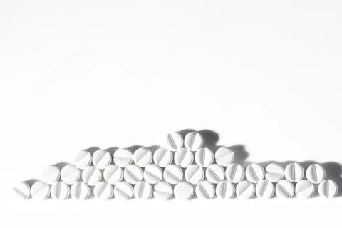 Stack of White Pills Arranged on Clean Minimalistic Background Stock Photos