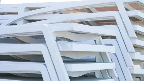 A stack of white plastic sun loungers or beach chairs Stock Photos