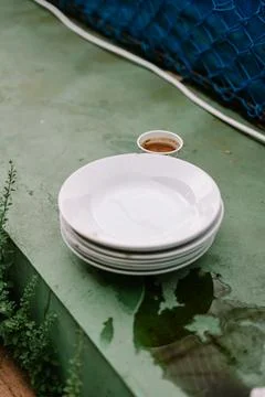 Stack of White Plates and Coffee Cup on Textured Green Surface Stock Photos
