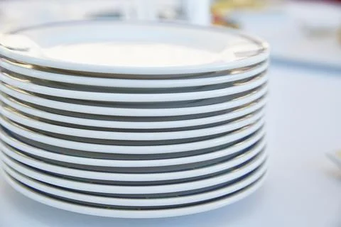 A stack of white plates on a light background. Life style Stock Photos