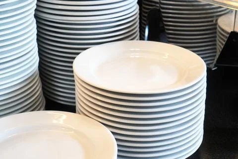 Stack of white plates in a restaurant Stock Photos