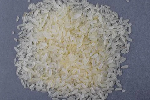 Stack of white rice grains gathered together in front on a light background Stock Photos
