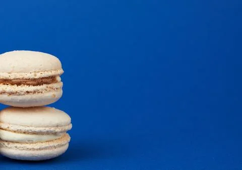Stack of white round baked almond flour cakes macarons on a dark blue backgro Stock-Fotos