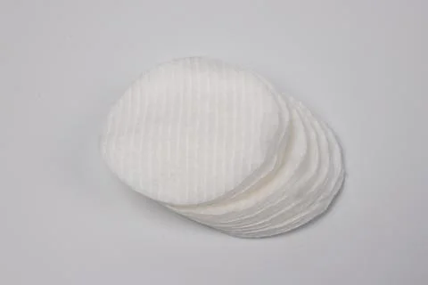 Stack of white round cotton pads on plain light background Stock Photos