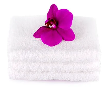 Stack white spa towels on white background  with purple  orchid flower. Stock Photos