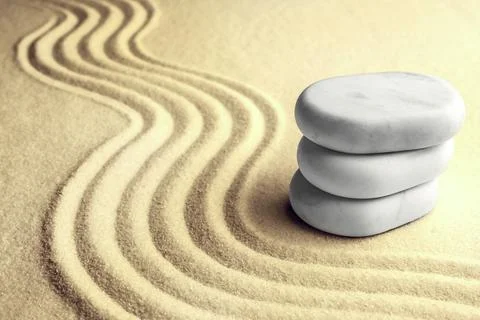 Stack of white stones on sand with pattern, space for text. Zen, meditation.. Stock Photos