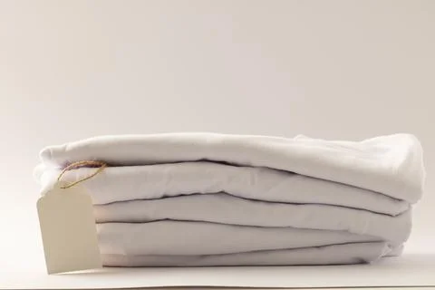 Stack of white t shirts with tag and copy space on white background イラスト素材