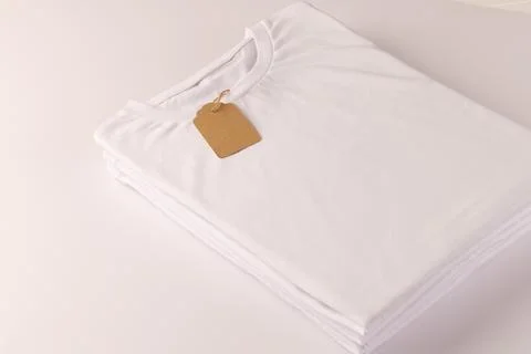 Stack of white t shirts with tag and copy space on white background Stock Illustration