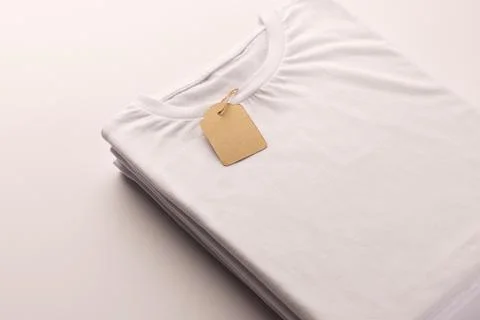 Stack of white t shirts with tag and copy space on white background Stock Illustration