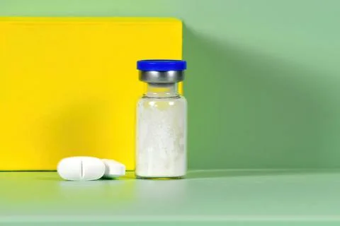 Stack of white tablets and medical vial Medicinal powder for saline injection Stock Photos