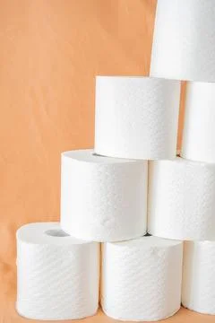 Stack of white toilet paper rolls arranged in pyramid on  plain background. S Stock Photos