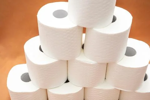Stack of white toilet paper rolls arranged in pyramid on  plain background. S Stock Photos