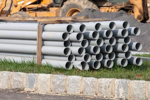 Stack of white water pipes on paving block Stock Photos