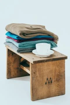 Stack of winter sweaters  and cafe on rustic bench Stockfoto's