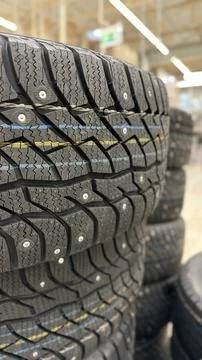 Stack of winter tires with visible treads in a store setting, suitable for .. Stock Photos
