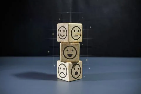 Stack of wooden blocks with face emoticon on dark background. Customer revi.. Stock Photos