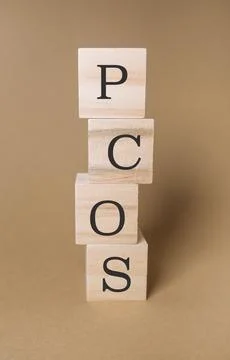 Stack of wooden blocks spell out the word PCOS Stockfoto's