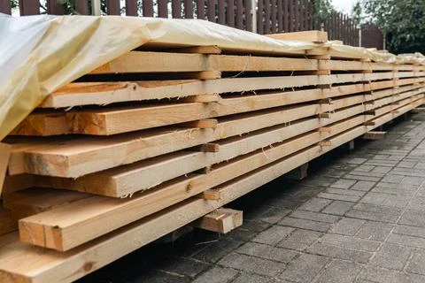 Stack of wooden boards. The boards appear rough-cut with visible knots and un Stock Photos