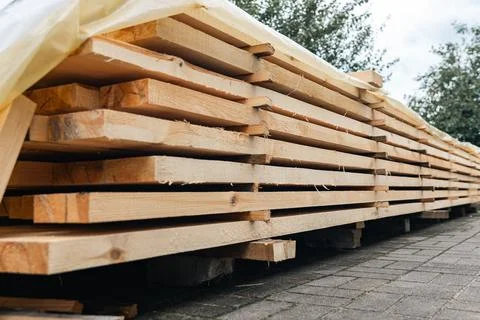 Stack of wooden boards. The boards appear rough-cut with visible knots and un Stock Photos