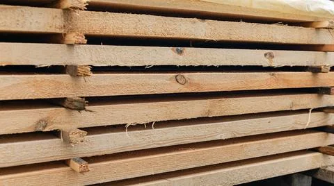 Stack of wooden boards. The boards appear rough-cut with visible knots and un Stock Photos