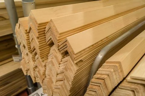 A stack of wooden corners board in store. Wooden products for construction and Stock Photos
