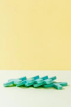 Stack of wooden crosses on yellow background concept abstract pattern minim.. Foto stock