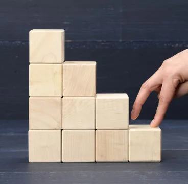 A stack of wooden cubes 6 the person's fingers go up the steps. Business grow Stockfoto's