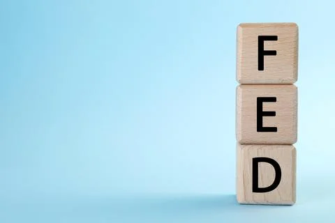 Stack of wooden cubes with letters Fed (Federal Reserve System) on light bl.. Stock Photos