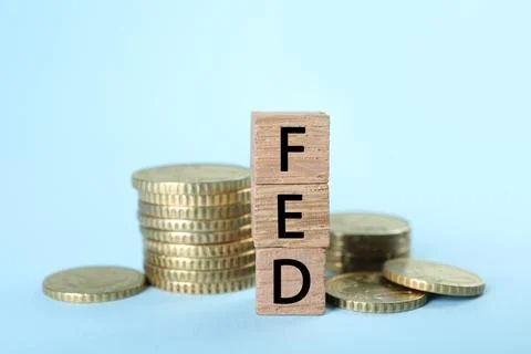 Stack of wooden cubes with letters Fed (Federal Reserve System) and coins o.. Stockfoto's