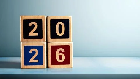 Stack of wooden cubes with the number 2026 on the table with a colored back.. 스톡 사진
