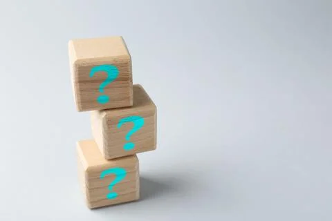 Stack of wooden cubes with question marks on light grey background, space f.. 스톡 사진