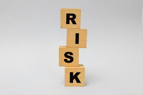 Stack of wooden cubes with word Risk on light grey background 写真素材