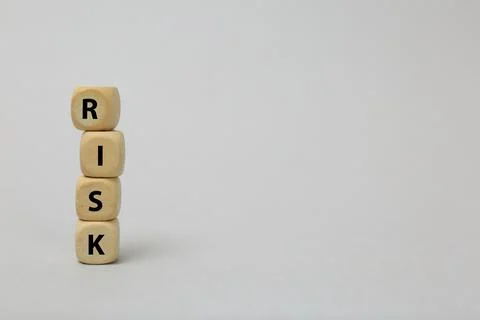 Stack of wooden cubes with word Risk on light grey background. Space for text Stockfoto's