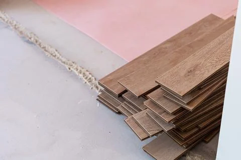 Stack of wooden flooring planks arranged neatly on a construction site with.. Stock Photos