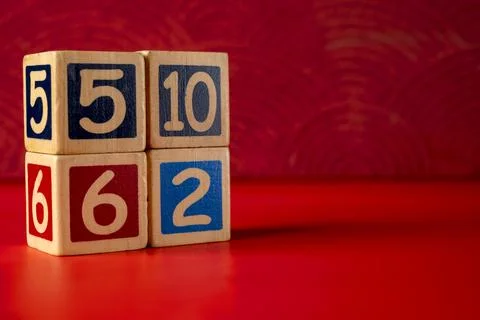 Stack of wooden number blocks with various numbers on a red background Stock Photos