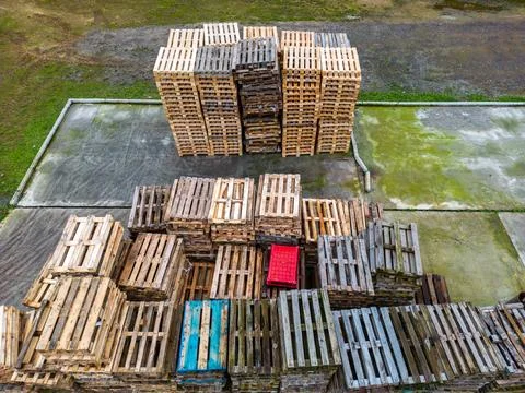 Stack of wooden pallets aerial view. Outdoor pallet storage area under the ro Stock Photos