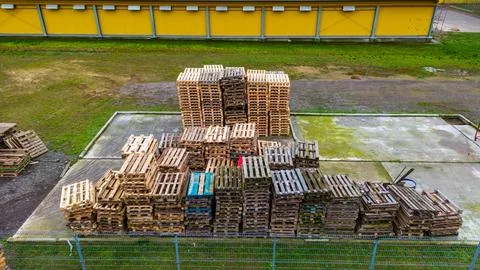 Stack of wooden pallets aerial view. Outdoor pallet storage area under the ro Stock Photos