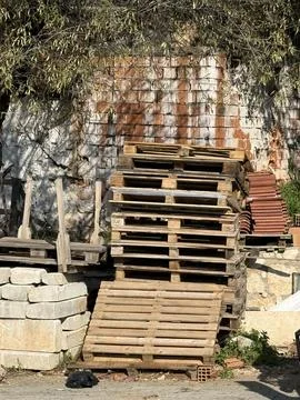 Stack of wooden pallets and bricks near textured wall outdoors, suitable fo.. Stock Photos