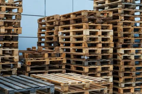 A stack of wooden pallets in an internal warehouse. An outdoor pallet storage Stock Photos