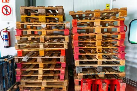 Stack of wooden pallets vacationed in logistics warehouse for order preparation. Stock Photos