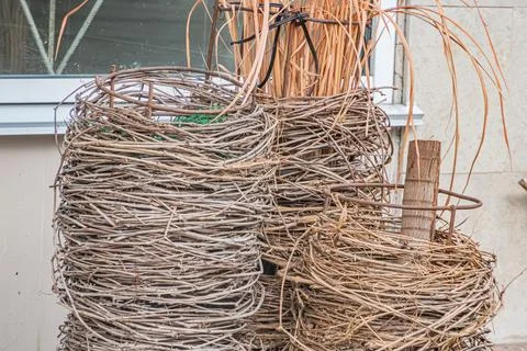 Stack of woven baskets against a white wall, varying sizes and shapes, natura Foto stock