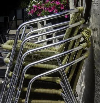 Stack of woven garden chairs with chrome frame Stock Photos