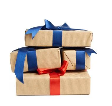 Stack of wrapped boxes in brown kraft paper and tied with silk ribbon, hol... Stock Photos