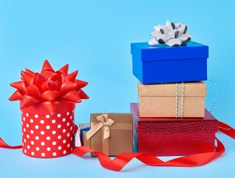 Stack of wrapped gifts with knotted bows on a blue background Foto stock