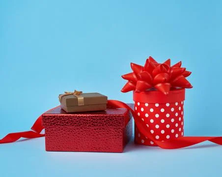 Stack of wrapped gifts with knotted bows on a blue background 스톡 사진