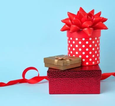 Stack of wrapped gifts with knotted bows on a blue background 스톡 사진